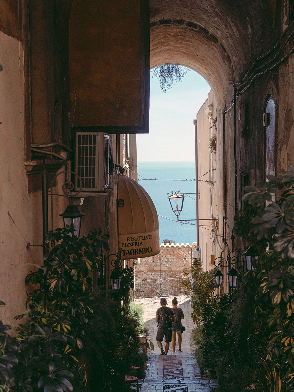 Taormina alley under an arch with sea view